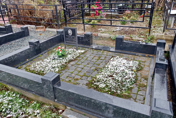 Место захоронения с памятной табличкой и двумя цветниками